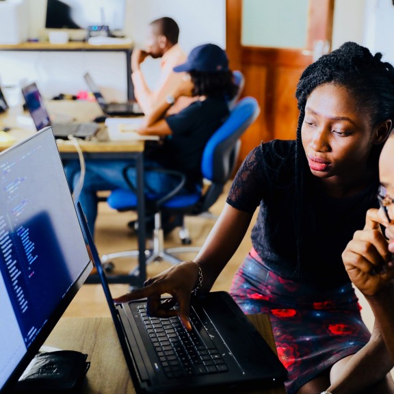 People sitting around a computer and discussing